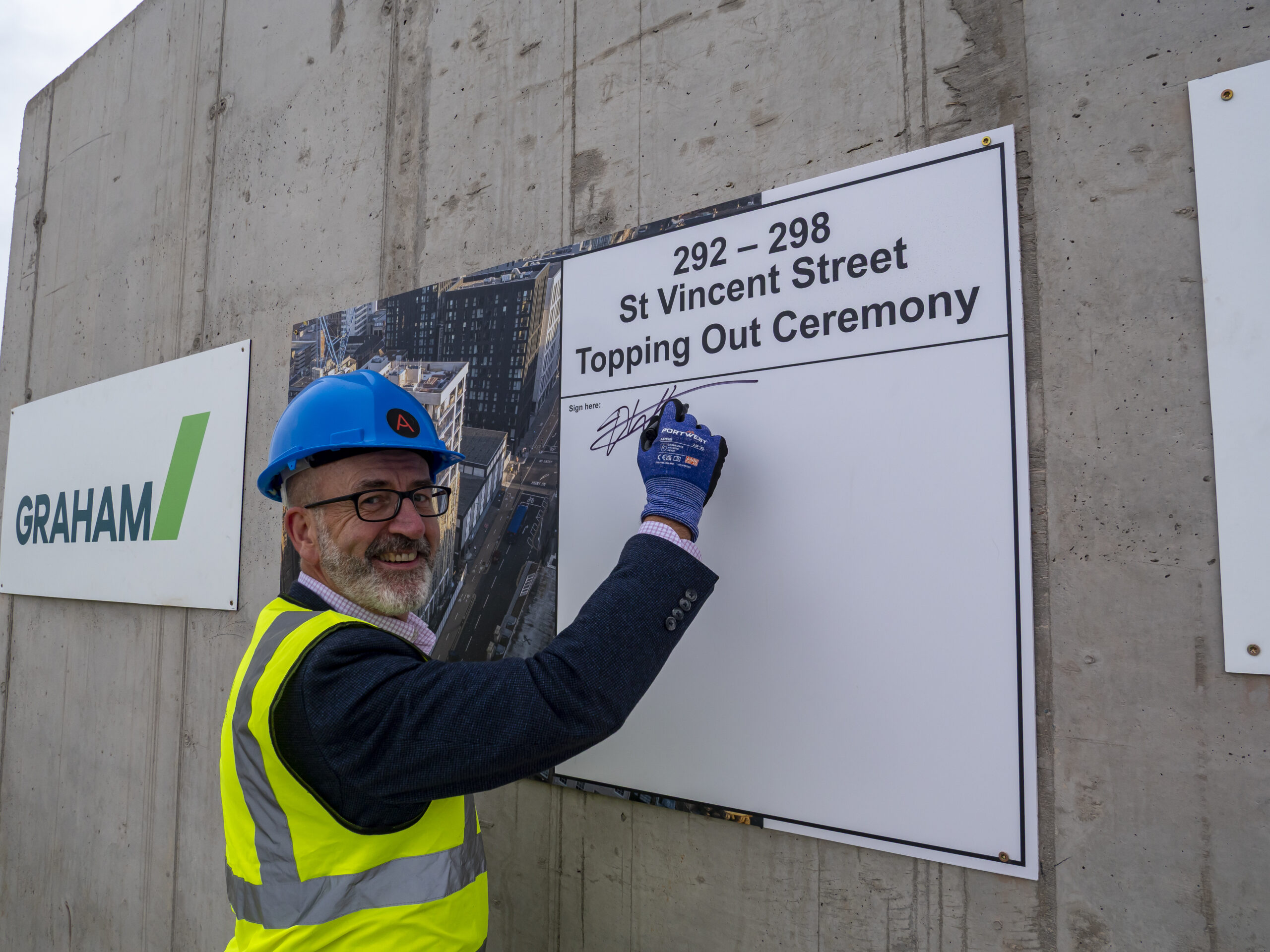 Signing the commemorative plaque at the St Vincent Studios topping-out ceremony